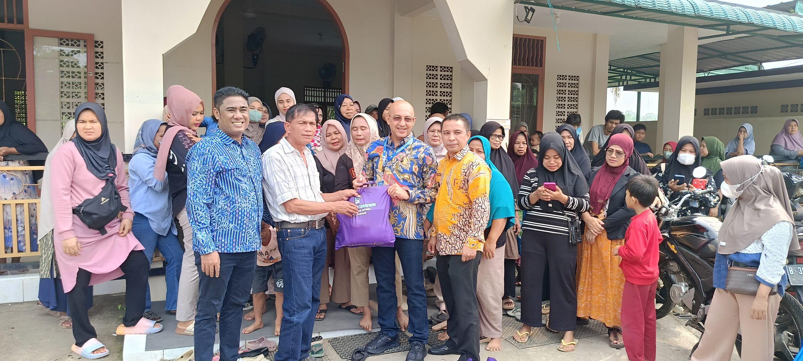 Direktur utama Perumda AM PADANG Hendra Pebrizal saat menyalurkan bantuan di Kampung Apa KPIK